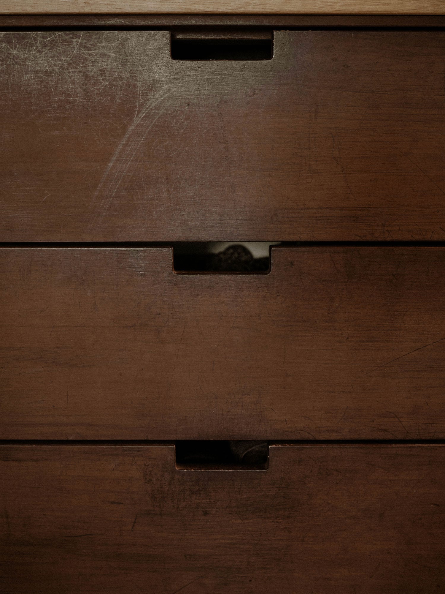 Drawer fronts on a brown chest of drawers with a beautiful patina