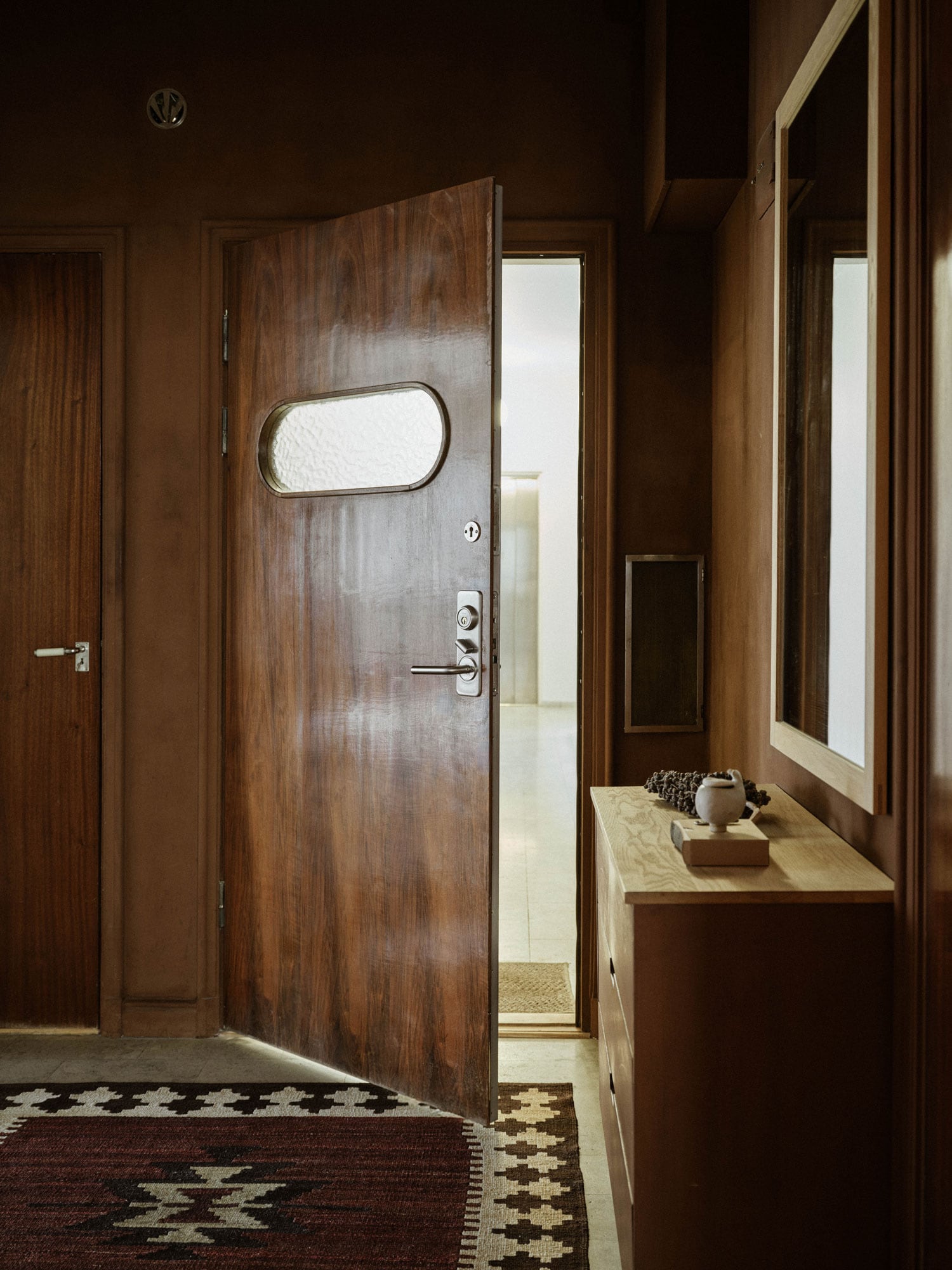Hallway with brown walls and the front door ajar